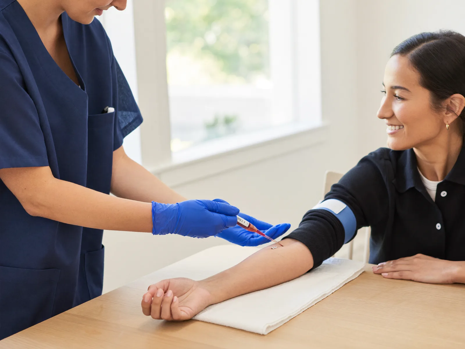 A blood draw performed at a dining room table