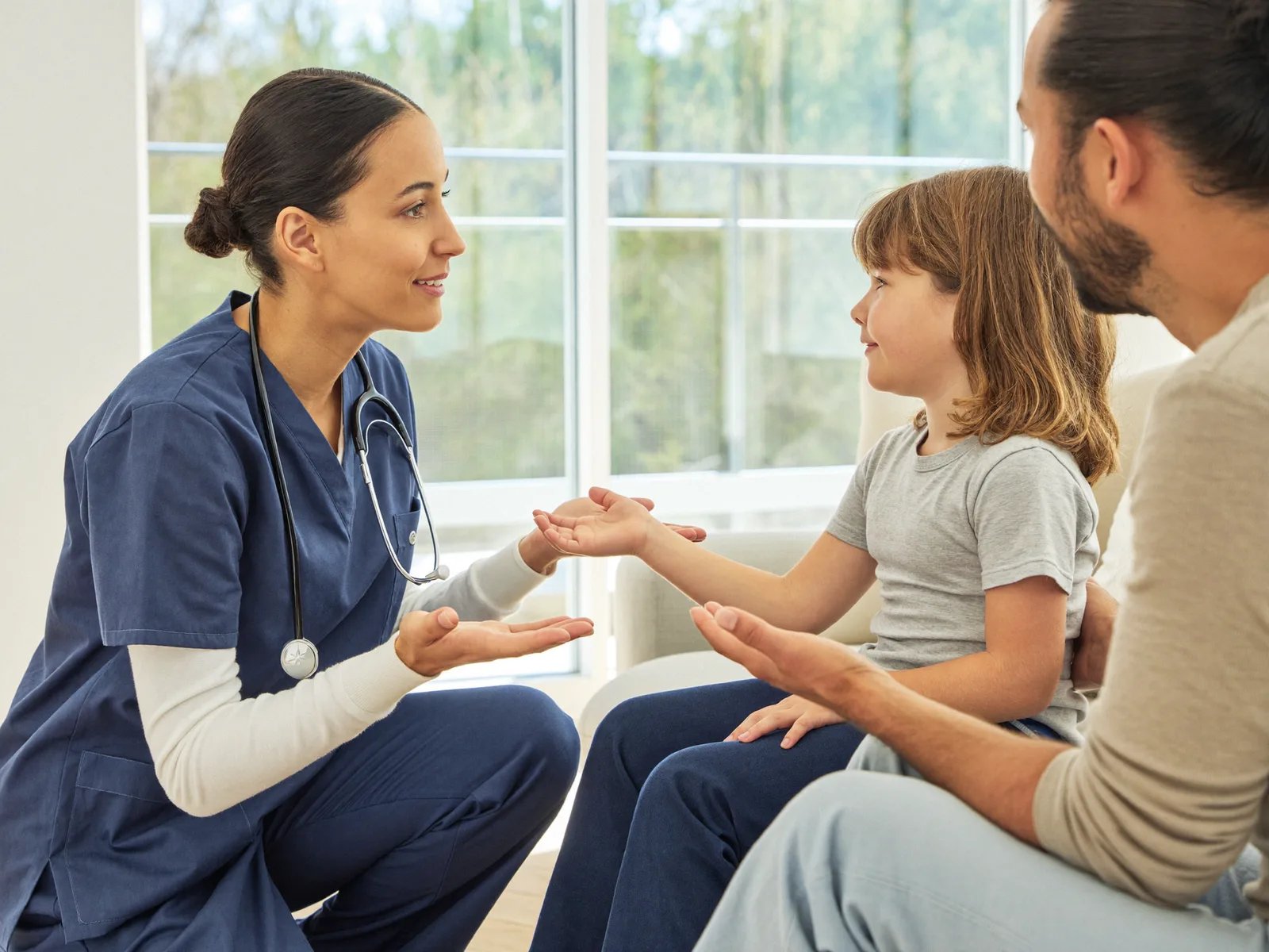 The nurse explaining the visit to a child beside their parent